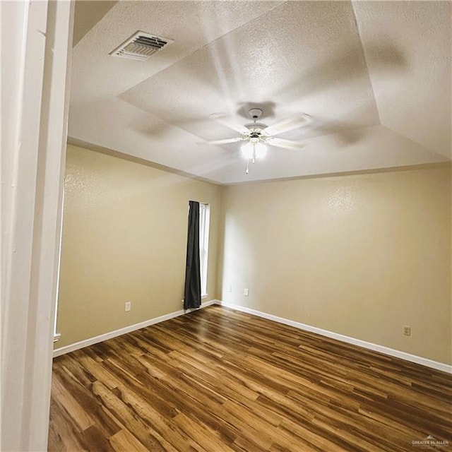 empty room with ceiling fan, hardwood / wood-style floors, and a textured ceiling