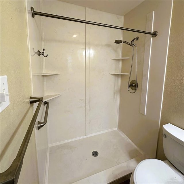 bathroom with toilet and a shower