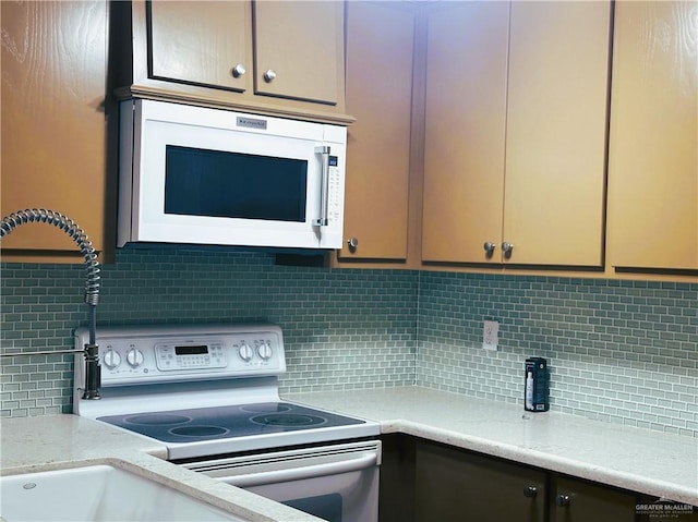 kitchen with white appliances, light stone countertops, and decorative backsplash