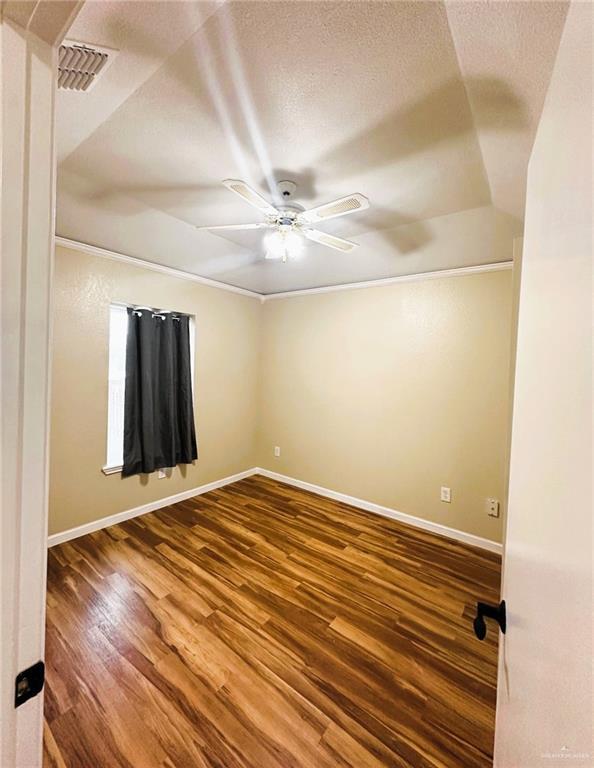 unfurnished room with wood-type flooring, a textured ceiling, and ceiling fan