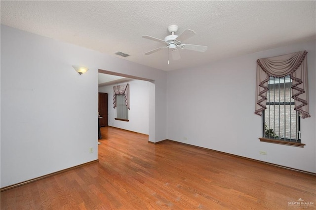 spare room with ceiling fan, a textured ceiling, and hardwood / wood-style flooring