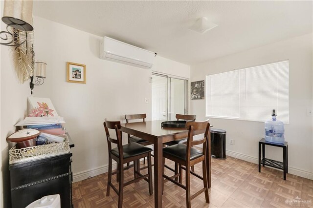 dining area featuring parquet flooring and a wall unit AC