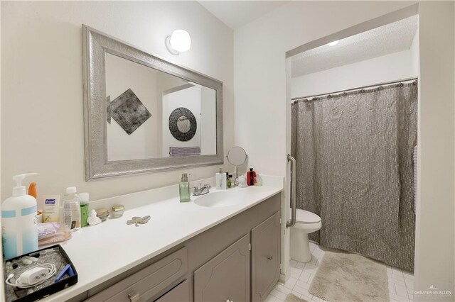 bathroom with tile patterned flooring, vanity, a textured ceiling, and toilet