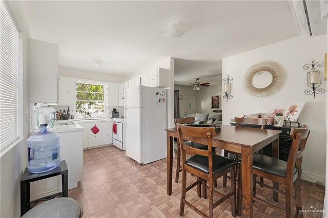 kitchen featuring white cabinets, white appliances, and ceiling fan