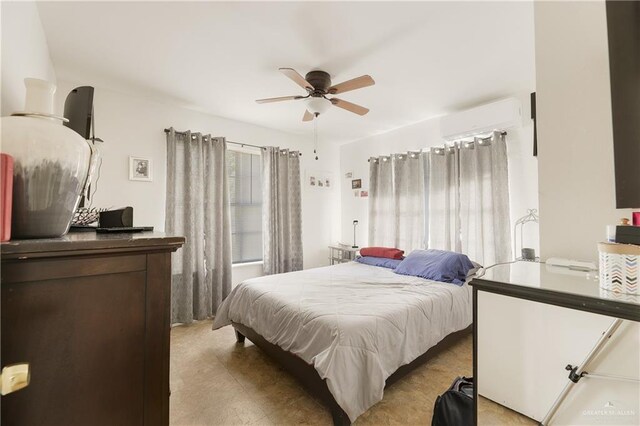 bedroom with a wall unit AC and ceiling fan