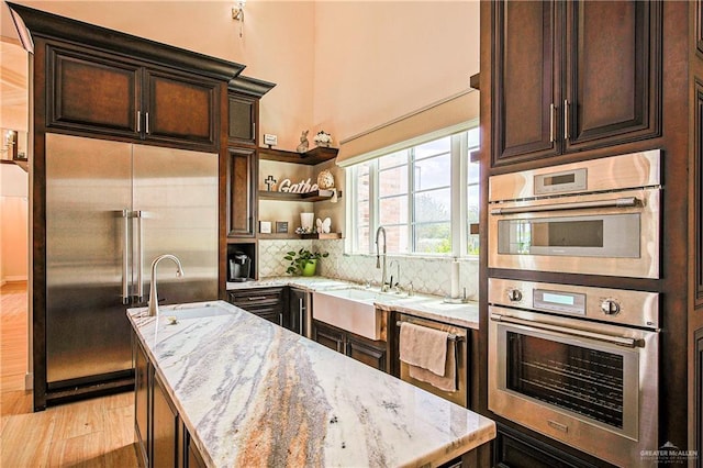 4835 Bryan Rd, Palmhurst, TX 78573 - kitchen with appliances with stainless steel finishes, light wood finished floors, a center island, light stone countertops, and decorative backsplash