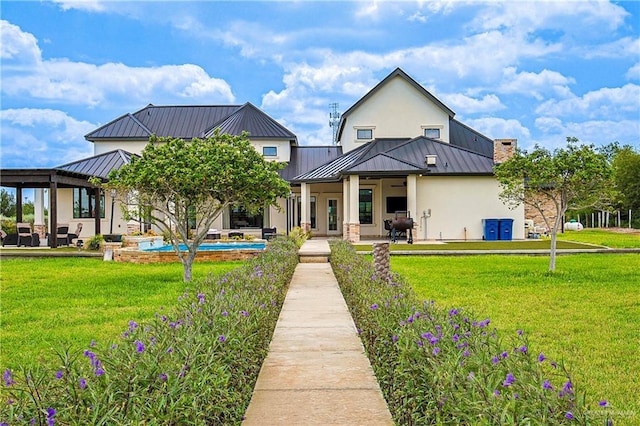 4835 Bryan Rd, Palmhurst, TX 78573 - back of house with stucco siding, a standing seam roof, a patio, and a lawn