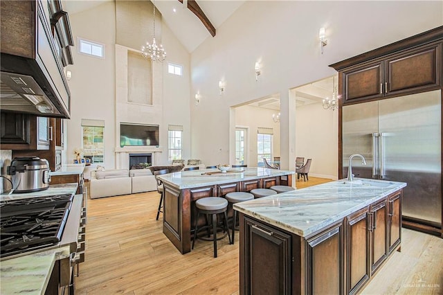 4835 Bryan Rd, Palmhurst, TX 78573 - kitchen with an island with sink, built in refrigerator, a chandelier, high vaulted ceiling, and open floor plan