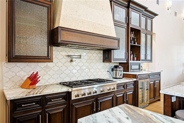 4835 Bryan Rd, Palmhurst, TX 78573 - kitchen featuring stainless steel gas cooktop, beverage cooler, dark brown cabinets, and backsplash