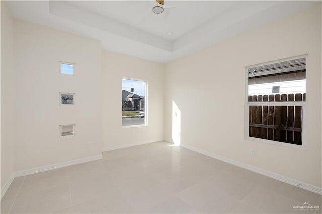 spare room featuring light tile patterned floors and a raised ceiling