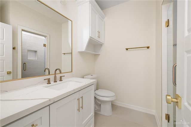 bathroom featuring tile patterned flooring, vanity, toilet, and walk in shower