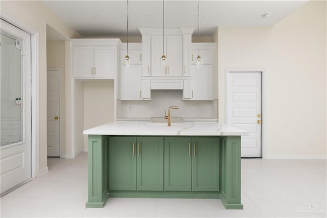 kitchen featuring sink, green cabinetry, white cabinetry, hanging light fixtures, and an island with sink