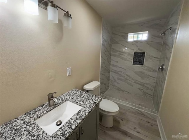 2505 W Bella Vista Ave W, Alton, TX 78573 - bathroom with toilet, tiled shower, vanity, and wood finished floors