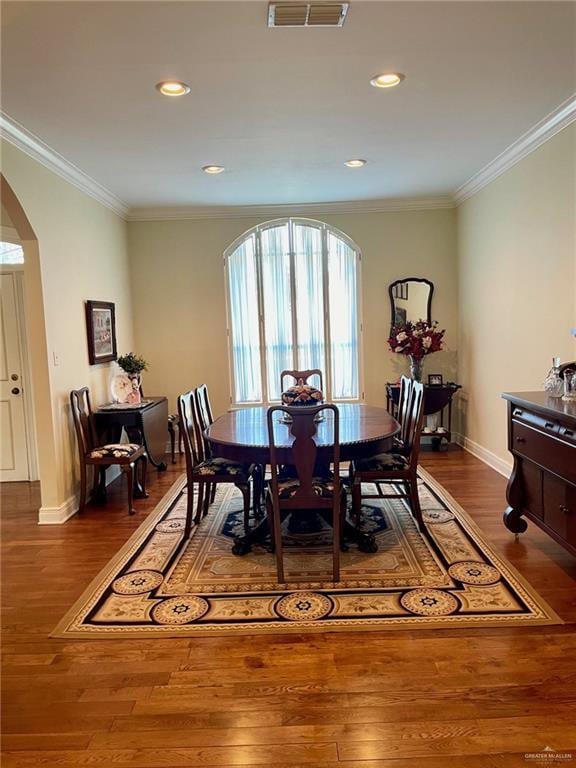 dining area featuring dark hardwood / wood-style flooring and crown molding