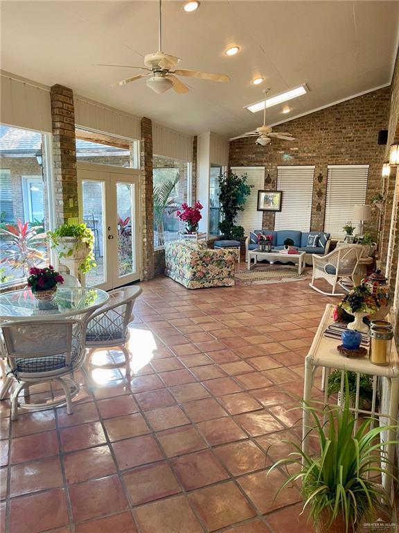 interior space with lofted ceiling, french doors, and ceiling fan