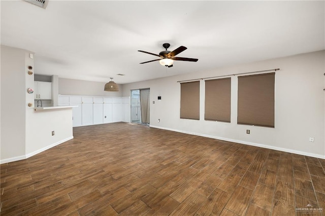 3838 View Point Dr, Edinburg, TX 78542 - unfurnished living room featuring a ceiling fan, baseboards, and dark wood-type flooring