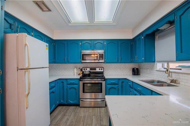 kitchen featuring sink, stainless steel appliances, and blue cabinets