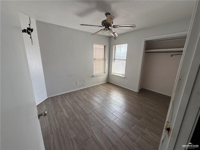 unfurnished bedroom with ceiling fan, dark hardwood / wood-style floors, and a closet