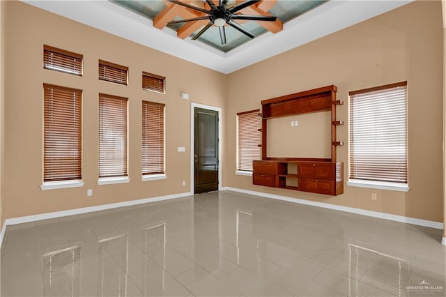 tiled spare room with ceiling fan