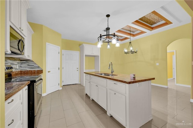 kitchen with an inviting chandelier, white cabinets, sink, an island with sink, and stainless steel appliances