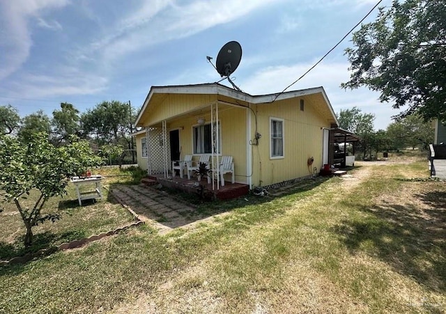 exterior space with covered porch and a lawn