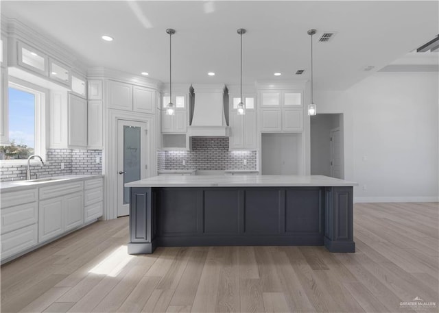 1405 Helen Dr, Weslaco, TX 78599 - kitchen featuring custom range hood, a sink, white cabinetry, backsplash, and recessed lighting