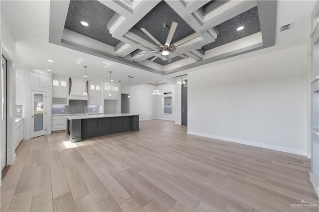 1405 Helen Dr, Weslaco, TX 78599 - kitchen with coffered ceiling, white cabinetry, open floor plan, light countertops, and light wood-type flooring
