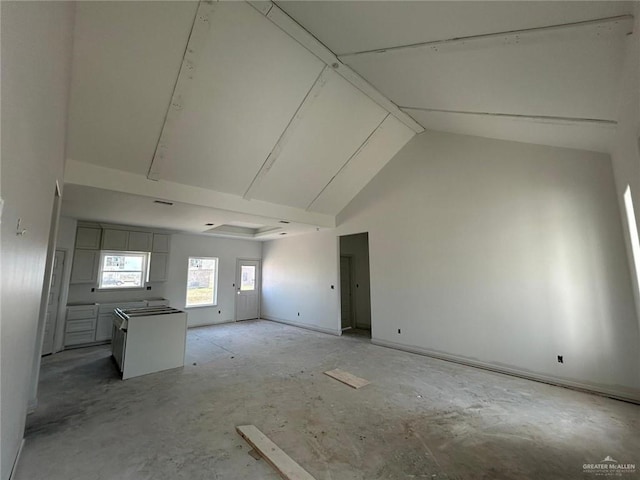 unfurnished living room with high vaulted ceiling