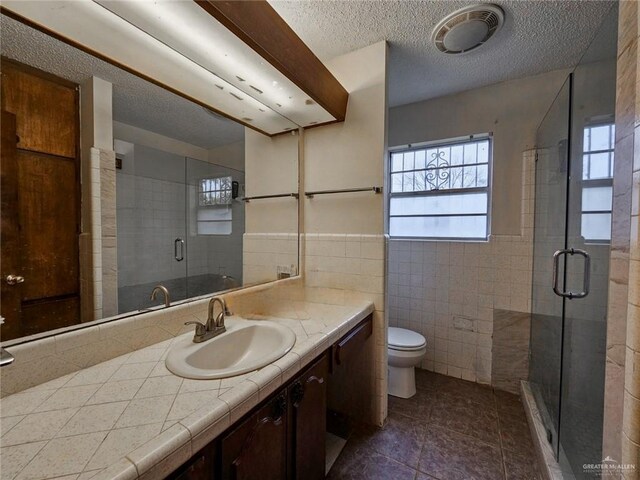 905 E Ithaca Ave, Mcallen, TX 78501 - full bath with tile walls, tile patterned flooring, a shower stall, a textured ceiling, and vanity