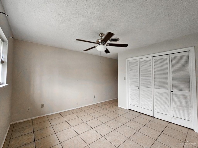 905 E Ithaca Ave, Mcallen, TX 78501 - unfurnished bedroom featuring a textured ceiling, a closet, light tile patterned flooring, baseboards, and a ceiling fan