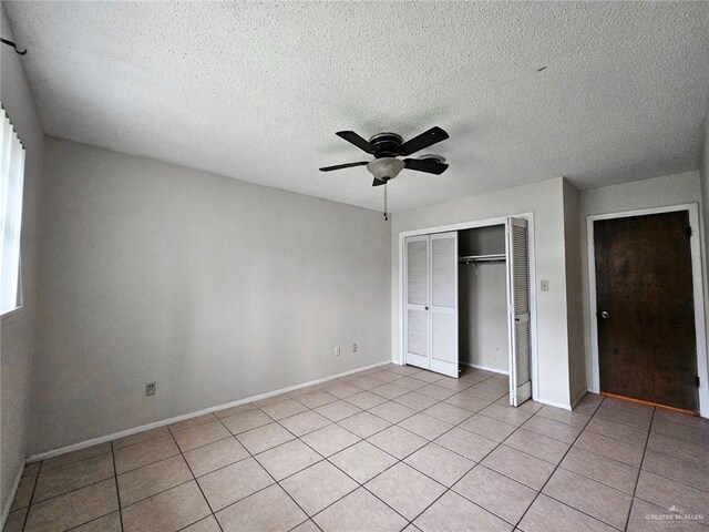 905 E Ithaca Ave, Mcallen, TX 78501 - unfurnished bedroom featuring a closet, baseboards, light tile patterned floors, a textured ceiling, and a ceiling fan