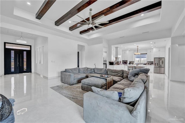 living area featuring a tray ceiling, beamed ceiling, and ceiling fan