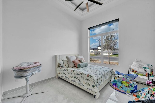 bedroom with a tray ceiling, a ceiling fan, baseboards, and concrete floors