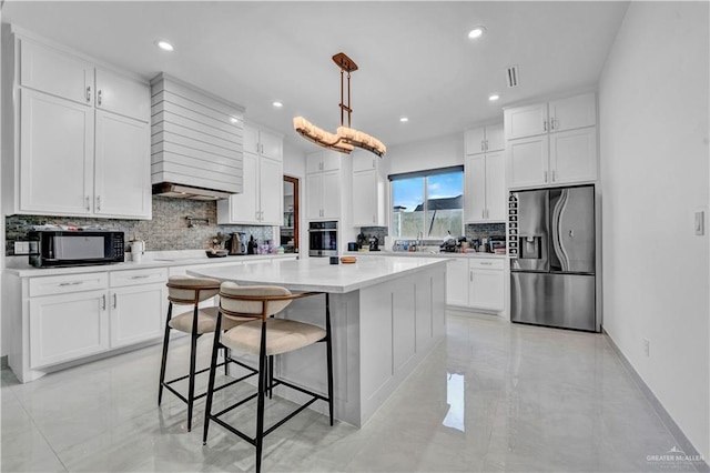 kitchen featuring a kitchen breakfast bar, white cabinets, light countertops, and stainless steel appliances