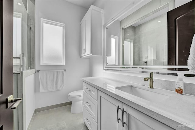 bathroom with tile patterned floors, toilet, a stall shower, baseboards, and vanity