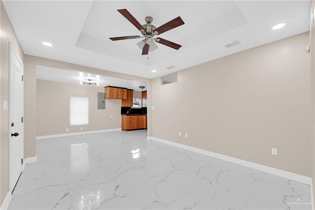 410 W 7th St, San Juan, TX 78589 - unfurnished living room featuring electric panel, a tray ceiling, a ceiling fan, light marble finish flooring, and recessed lighting
