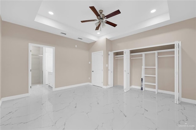410 W 7th St, San Juan, TX 78589 - unfurnished bedroom with a tray ceiling, recessed lighting, light marble finish floors, ensuite bathroom, and multiple closets