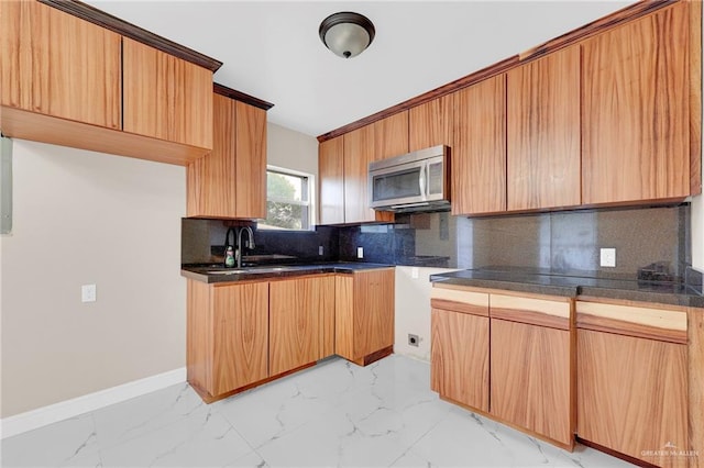 410 W 7th St, San Juan, TX 78589 - kitchen featuring stainless steel microwave, light marble finish flooring, decorative backsplash, and dark countertops