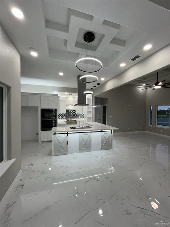 kitchen featuring white cabinetry, coffered ceiling, a kitchen island, and pendant lighting