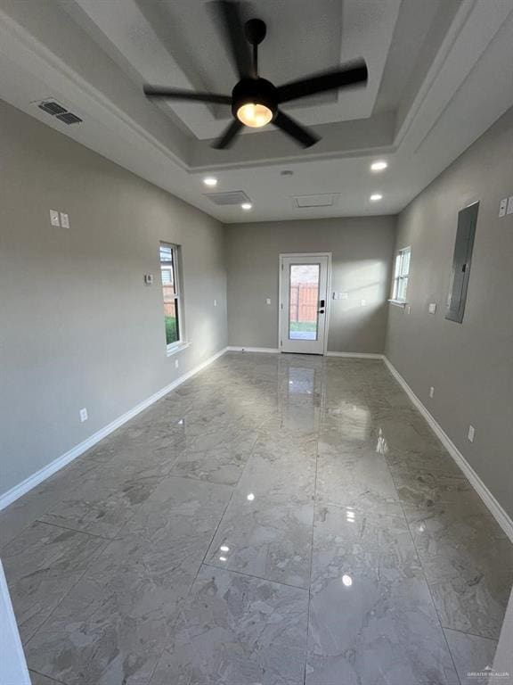 unfurnished room featuring ceiling fan, electric panel, and a raised ceiling