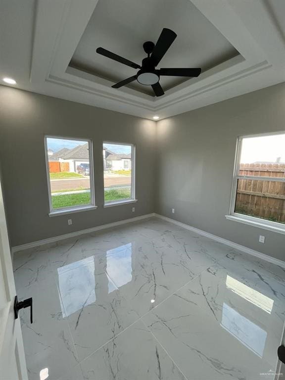 unfurnished room featuring ceiling fan and a tray ceiling