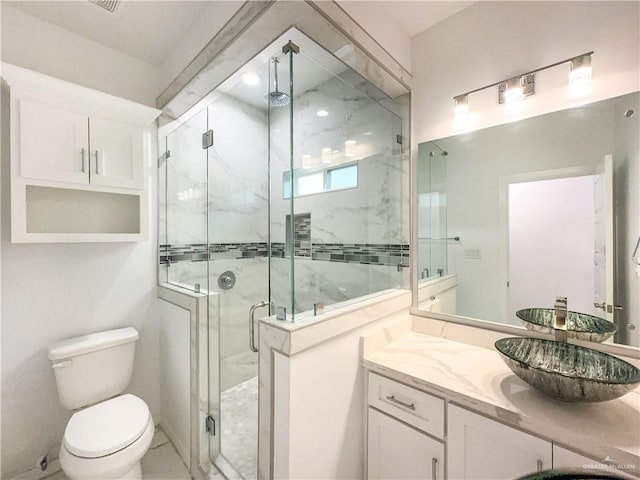 bathroom featuring vanity, toilet, and an enclosed shower