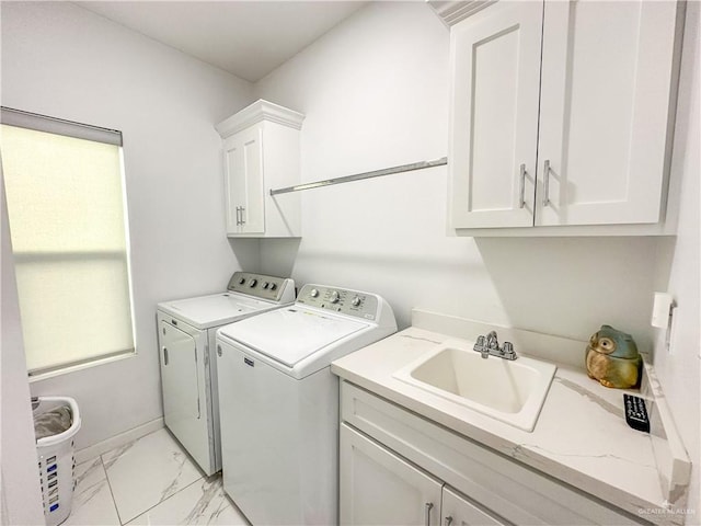 laundry room with independent washer and dryer, cabinets, and sink