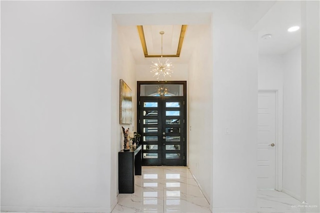 foyer featuring an inviting chandelier and french doors