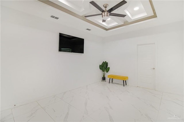 empty room featuring coffered ceiling and ceiling fan