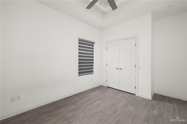 907 W Carmel Ave, Pharr, TX 78577 - unfurnished bedroom with wood finished floors, a raised ceiling, a closet, and baseboards