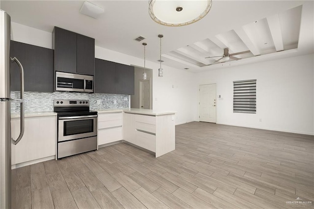 907 W Carmel Ave, Pharr, TX 78577 - kitchen with stainless steel appliances, open floor plan, a raised ceiling, light countertops, and a peninsula