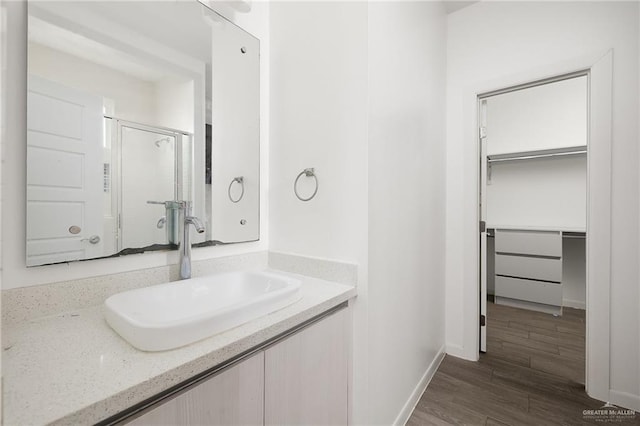 907 W Carmel Ave, Pharr, TX 78577 - full bath featuring vanity, wood finished floors, baseboards, a walk in closet, and an enclosed shower