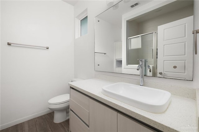 907 W Carmel Ave, Pharr, TX 78577 - bathroom featuring vanity, toilet, wood finished floors, a shower stall, and baseboards