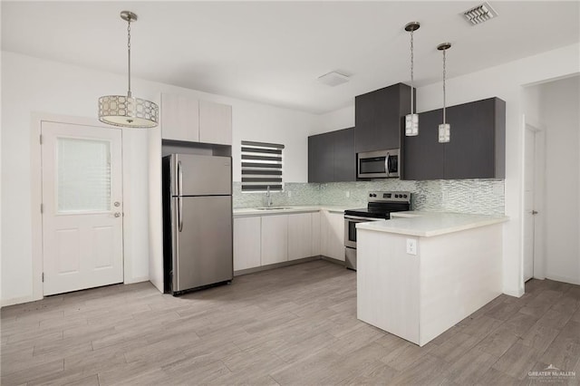 907 W Carmel Ave, Pharr, TX 78577 - kitchen featuring stainless steel appliances, light countertops, a peninsula, a sink, and tasteful backsplash